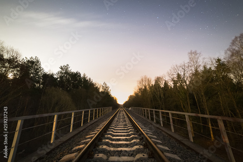 Railway track in the forest at cold starry night