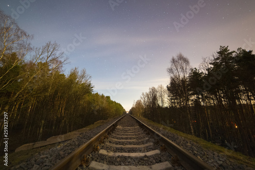 Railway track in the forest at cold starry night