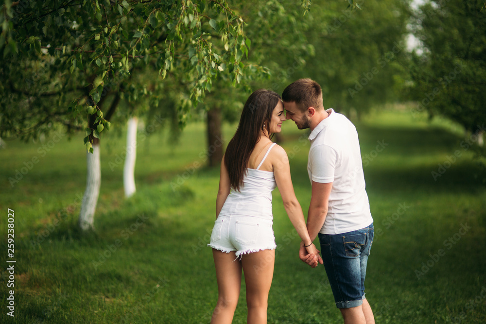 Man and girl walking around the park. Beautiful couple Man and girl walking around the park. Beautiful couple