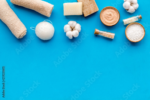 Organic cosmetics and eco materials for homemade spa on blue background top view mock up