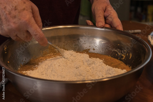 adding and mixing in flour into a bowl