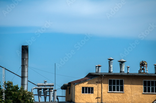 Top of obsolete vintage industrial building and facilities on blue sky background