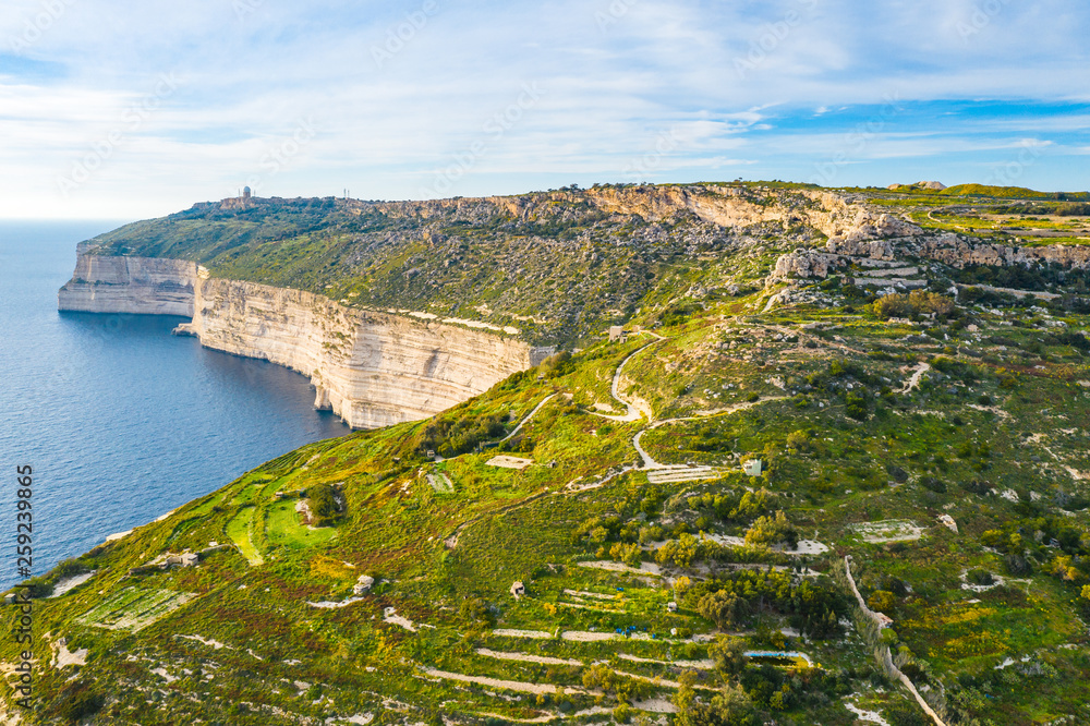 Aerial view of Dingli cliffs. Greeny nature and blue sea and blue sky. Malta island. 