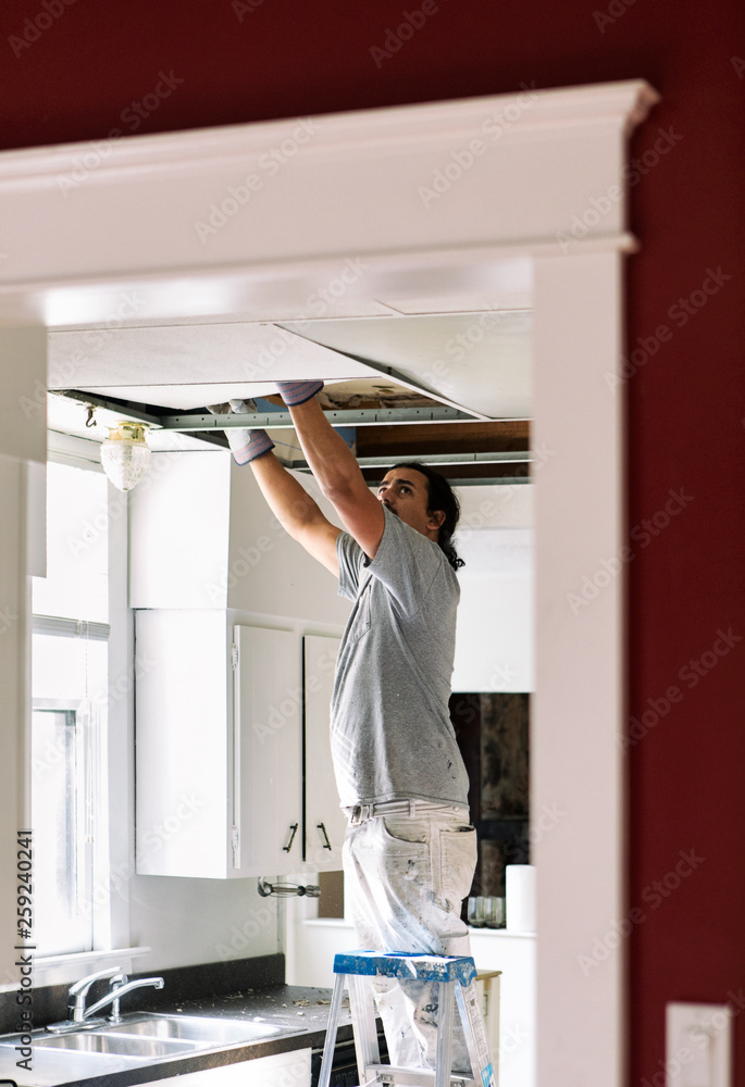 Kitchen: Man Removing Drop Ceiling Tiles Kitchen: Man Removing Drop Ceiling Tiles