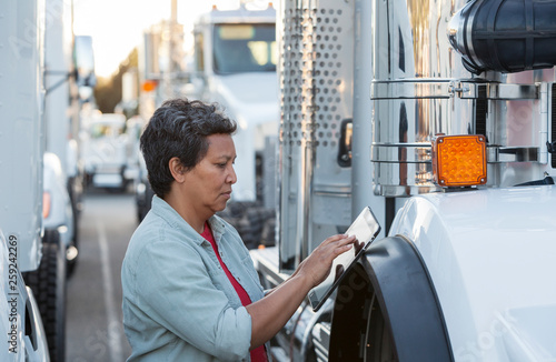 Female truck driver and fleet of trucks.