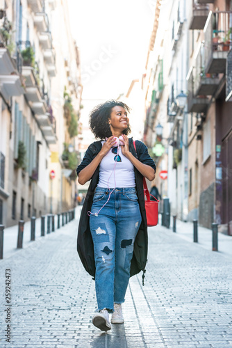 Beautiful Afro American Girl Listening Music on Headphones Outdoors.