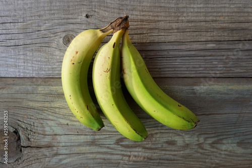 3 fresh bananas on an old wood background. Vegan food. Organic. Healthy eating. 