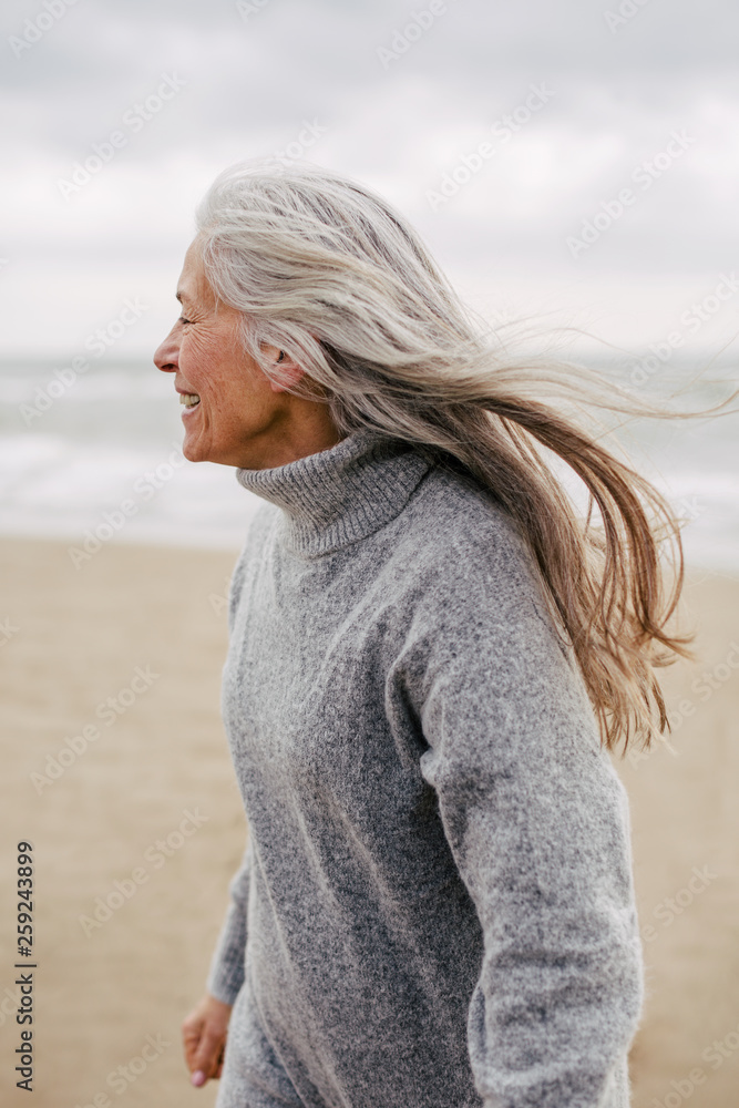 Active senior woman enjoying on the beach in winter. Active senior woman enjoying on the beach in winter.