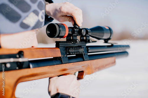 Closeup man's hands fixing the rifle scope photo