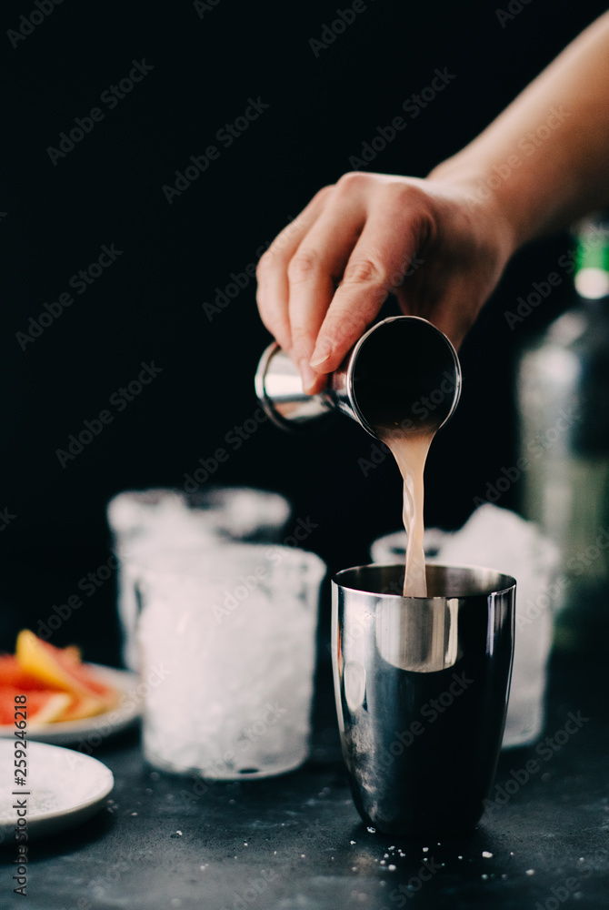 Pouring grapefruit juice into a shaker while making cocktails Pouring grapefruit juice into a shaker while making cocktails