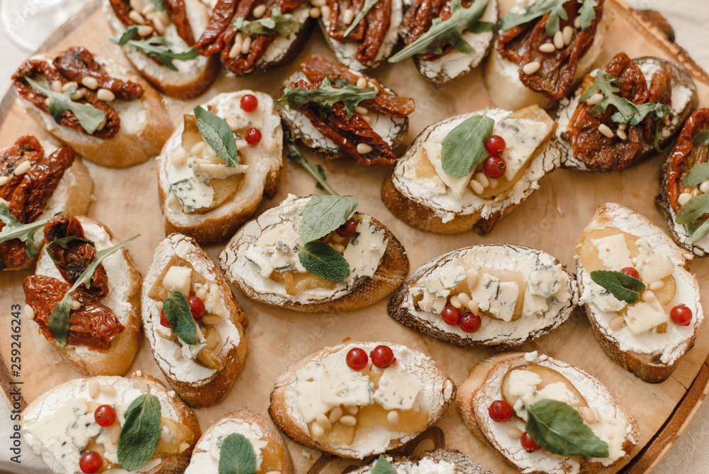 A variety of sandwiches and quick snacks - tapas on a wooden saw. Spanish specialty A variety of sandwiches and quick snacks - tapas on a wooden saw. Spanish specialty