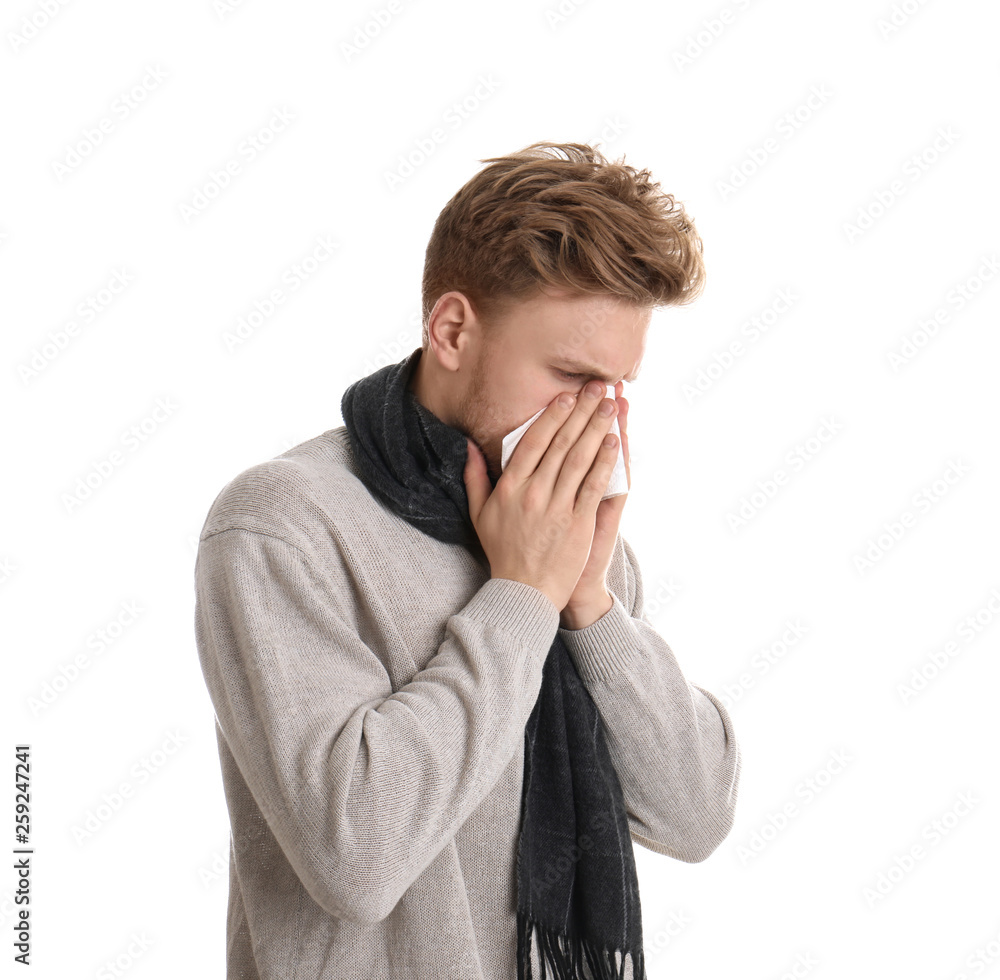 Handsome young man blowing nose against white background Handsome young man blowing nose against white background