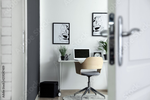 Stylish home office interior  view through open door