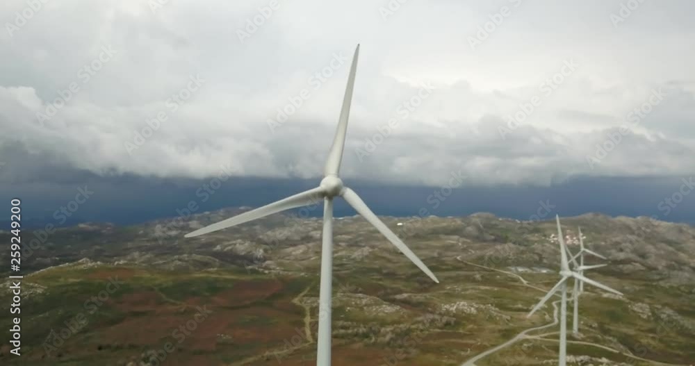 Detailed aerial view, by drone of a wind turbines on top of mountains, dramatic sky as background, in Portugal Detailed aerial view, by drone of a wind turbines on top of mountains, dramatic sky as background, in Portugal