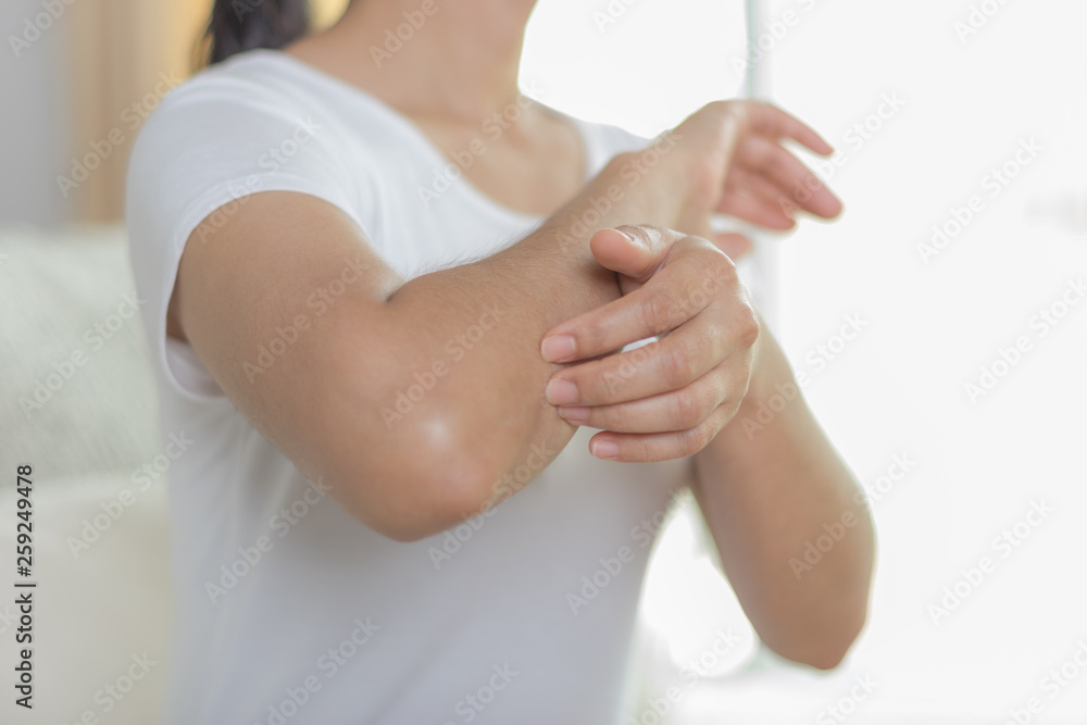 Health care and medical concept. Woman scratching her elbow.