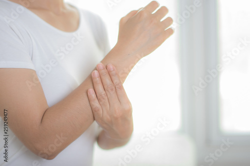 Closeup woman holds her wrist hand injury, feeling pain. Health care and medical conept.
