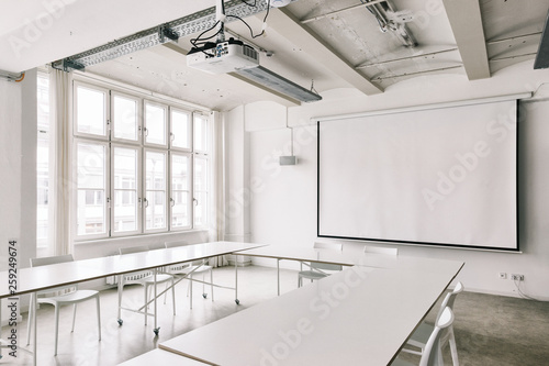 Bright White Industrial Conference Room with Projector and Scree