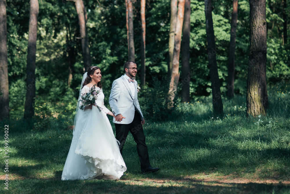 Bride and groom are walking in the woods on their wedding day Bride and groom are walking in the woods on their wedding day
