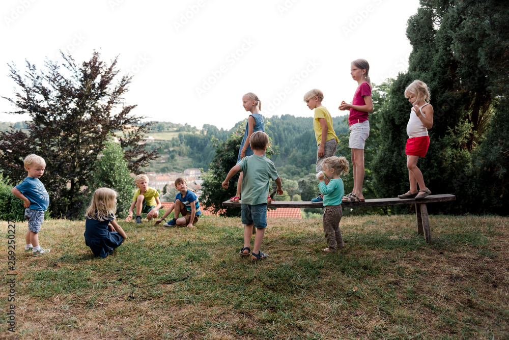 kids lining up on a bench with the intention of jumping off kids lining up on a bench with the intention of jumping off