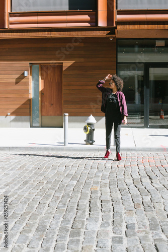 Young woman standing outside condo in city photo