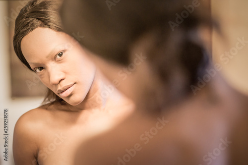 young black woman reflected in the mirror and smiling. Portrait
