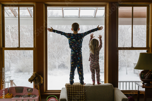 Brother and Sister Looking out window after snowstorm photo