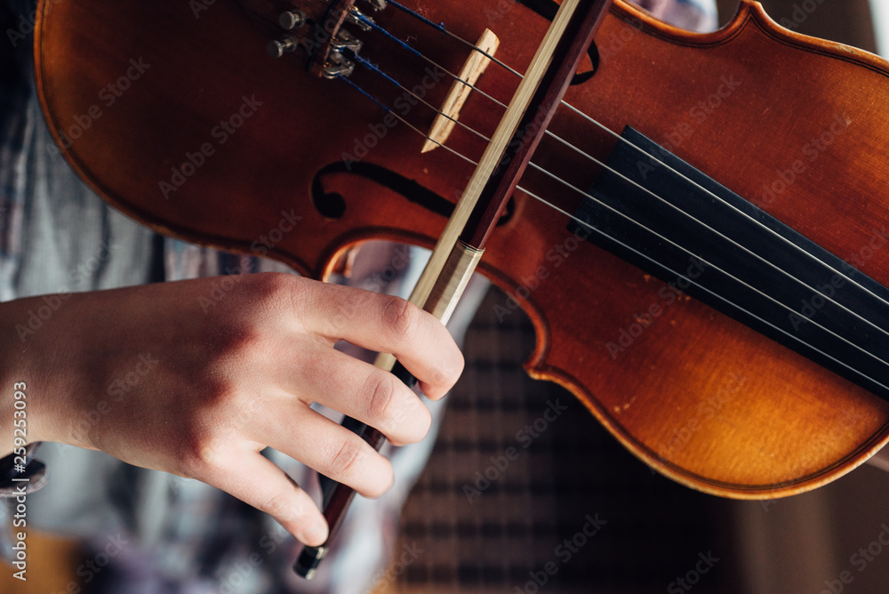 Girl's hand playing her violin from overhead Girl's hand playing her violin from overhead