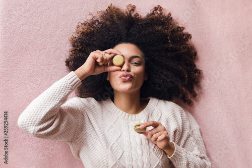 Young afro woman with macaron sweets photo