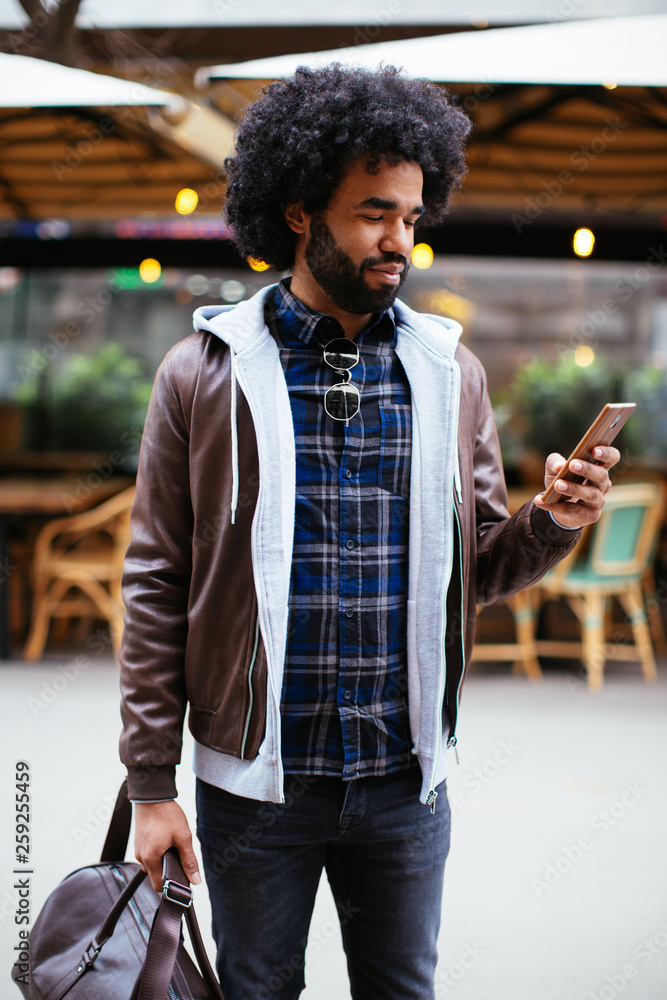 Afro man chatting on phone in the city. Afro man chatting on phone in the city.