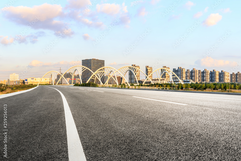Fototapeta premium Asphalt road and city skyline with bridge construction in shanghai at sunset