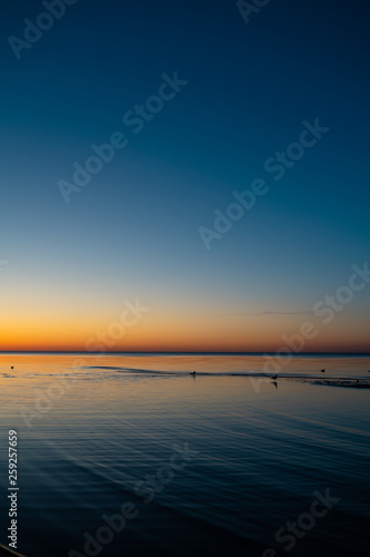 Vivid amazing sunset in Baltic States - Dusk in the sea with horizon illuminates by the sun © dissx