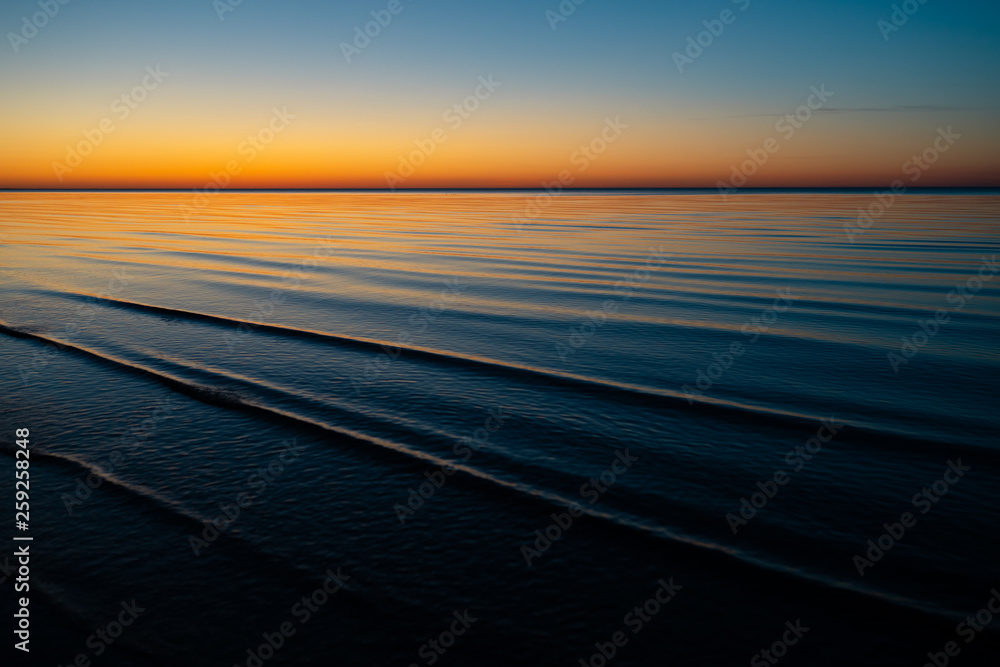 Vivid amazing sunset in Baltic States - Dusk in the sea with horizon illuminates by the sun