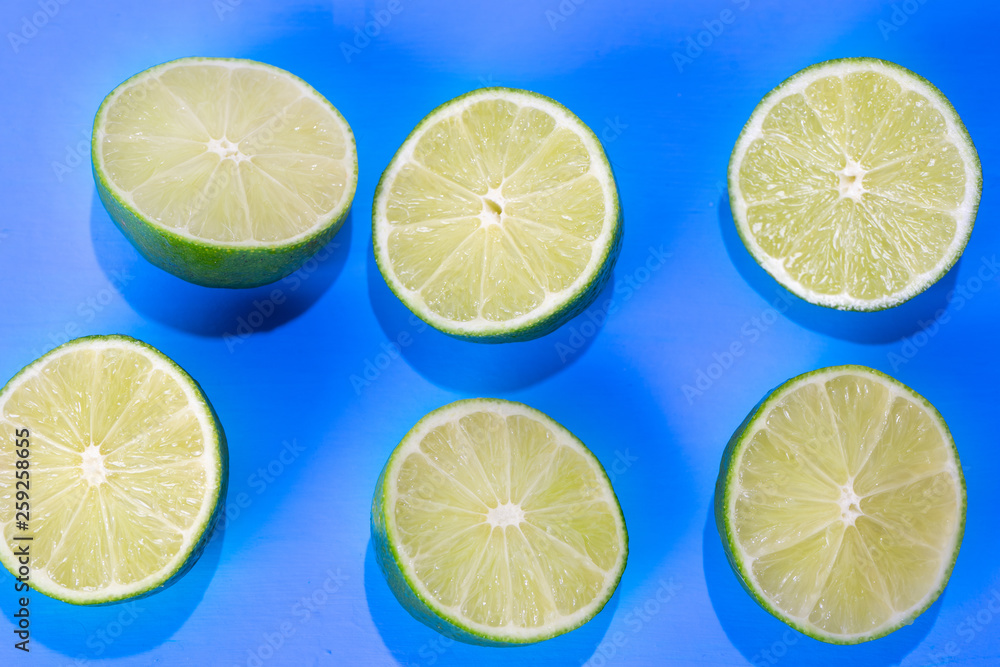 Green limes on colorful background