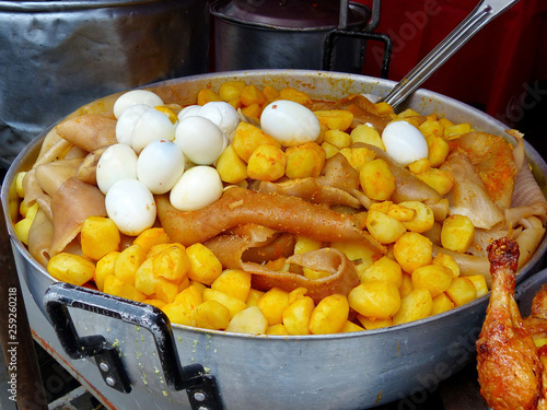 Big metal bowl with traditional delicious food of South America - potatoes, pig skin and eggs at food market in Cuenca, Azuay province, Ecuador photo