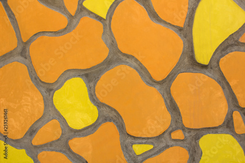yellow and orange oval spots of various shapes and sizes in gray cement. rough surface texture