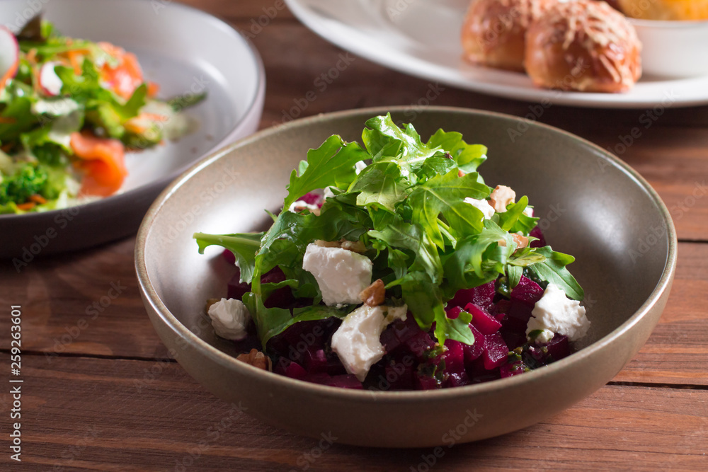 beetroot salad with blue cheese, arugula and walnut in a plate on a wooden background beetroot salad with blue cheese, arugula and walnut in a plate on a wooden background