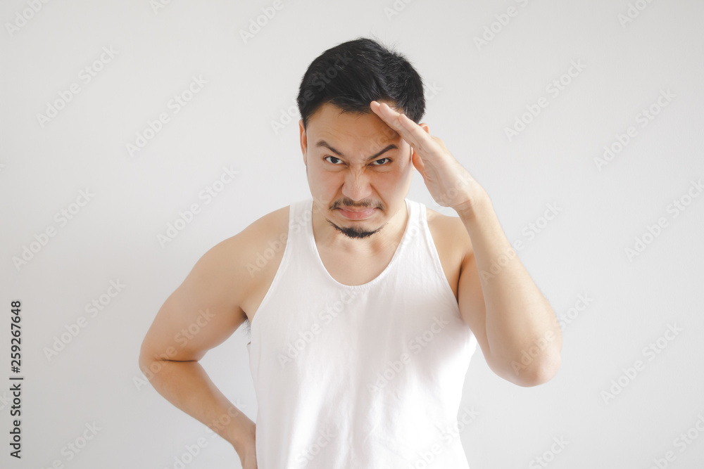 Man in white tank top with hot weather expression. Concept of hot weather of the sun in Asia. Man in white tank top with hot weather expression. Concept of hot weather of the sun in Asia.