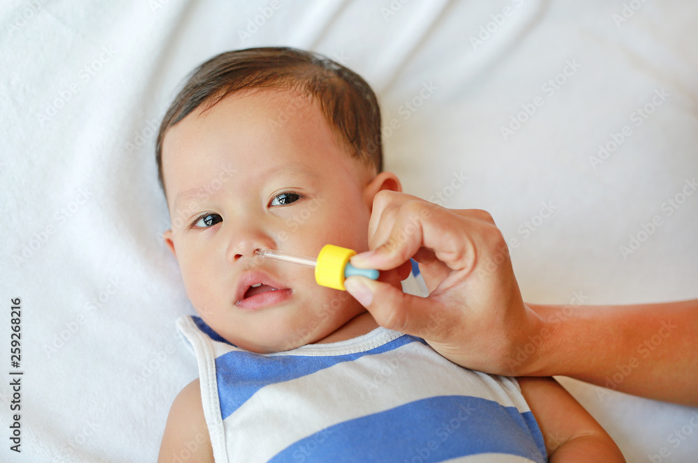 Asian baby boy gets nose drops. Baby care concept. Asian baby boy gets nose drops. Baby care concept.
