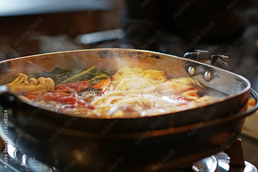 Hot pot of Japanese sukiyaki with ingredient of contrast color in a pot, meat and vegetable inside, fell hot from smoke that floats on top, traditional food of japan noodle, delicious food Hot pot of Japanese sukiyaki with ingredient of contrast color in a pot, meat and vegetable inside, fell hot from smoke that floats on top, traditional food of japan noodle, delicious food