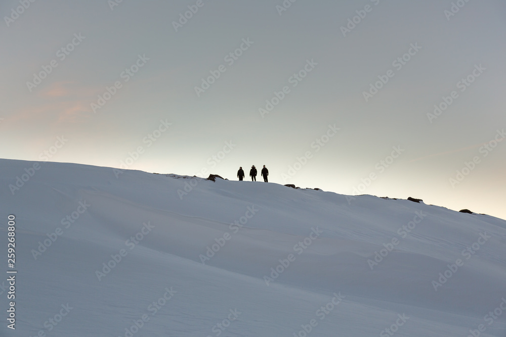 Three friends standing on snow covered mounting hill during glacier hike Three friends standing on snow covered mounting hill during glacier hike