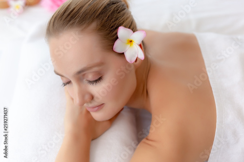 Charming beautiful young woman close eyes and feel relax, happiness in spa room at spa salon of luxury hotel or resort. Attractive beautiful girl wear towel. Gorgeous woman has nice skin, good health