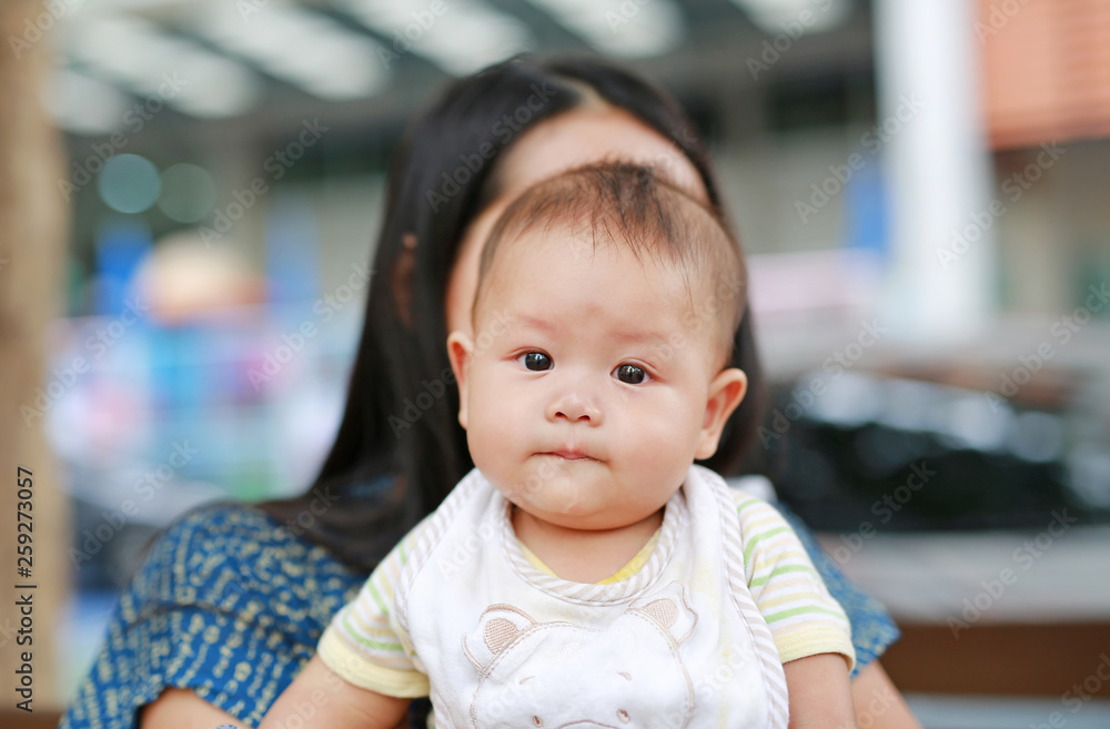 Adorable infant baby boy with mother holding outdoor.