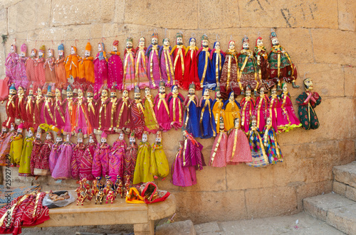 colorful puppets hanging on wall at Jaisalmer, Rajasthan, India © Paras