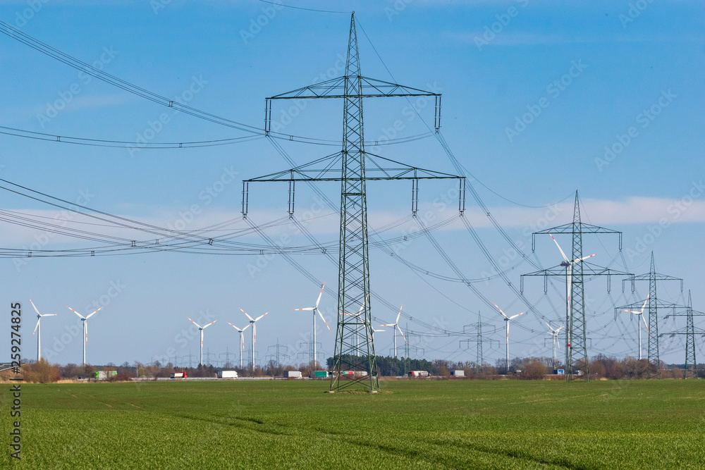 Windkraftpark und Überlandleitung bei strahlendem Sonnenschein Windkraftpark und Überlandleitung bei strahlendem Sonnenschein