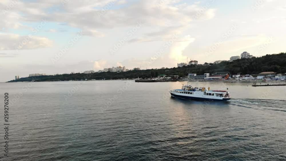 Drone view of the happy attractive man sitting on the pierce at seaside enjoying summer evening in the modern city. Odessa, Ukraine. Drone view of the happy attractive man sitting on the pierce at seaside enjoying summer evening in the modern city. Odessa, Ukraine.