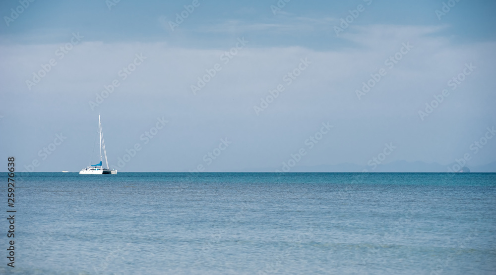 A white luxury private yacht at the tropical sea with bright sky near the Krabi Island, Thailand.