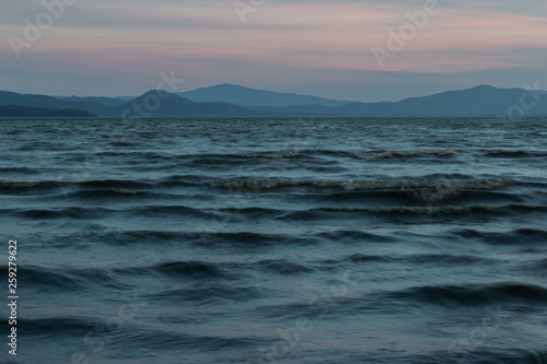 Close view of moving waves on a lake at dusk