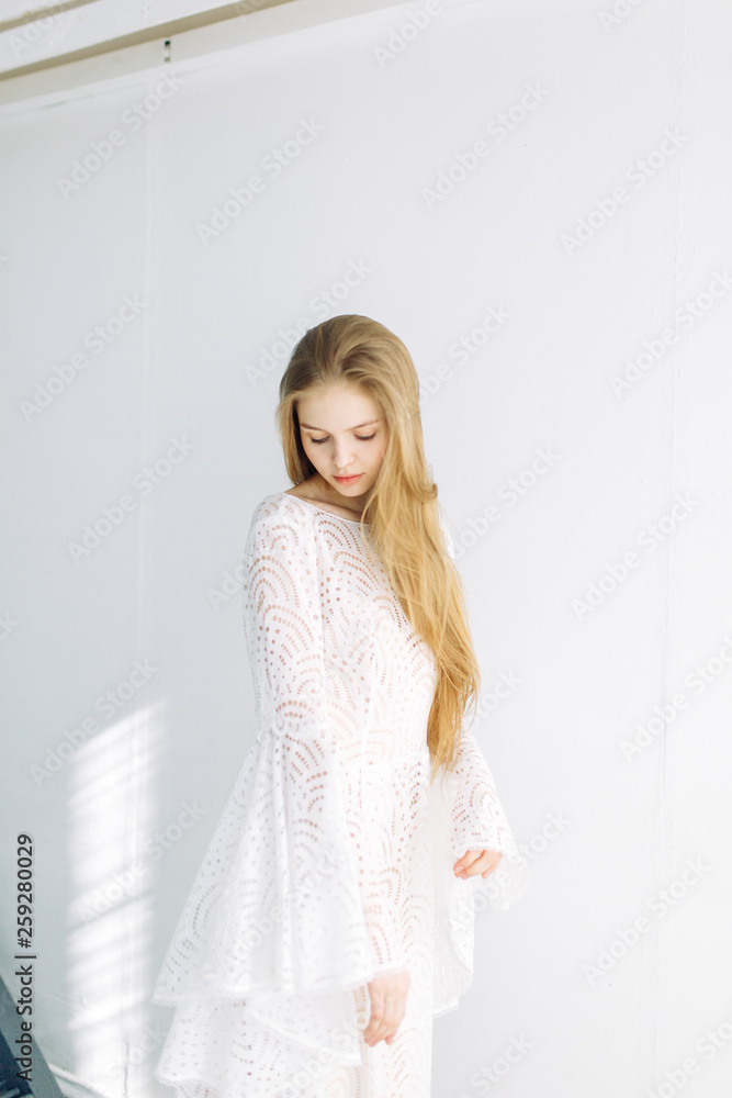 Beautiful bride on a white minimalistic background. Wedding preparations in fine art. Beautiful bride on a white minimalistic background. Wedding preparations in fine art.