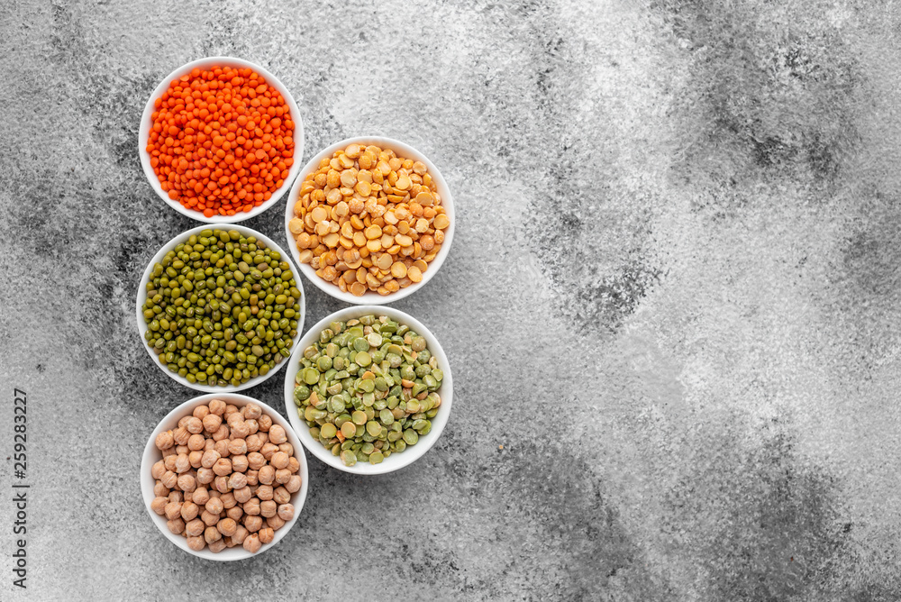 Variations of porridges and bean in white saucers on a gray concrete background Variations of porridges and bean in white saucers on a gray concrete background