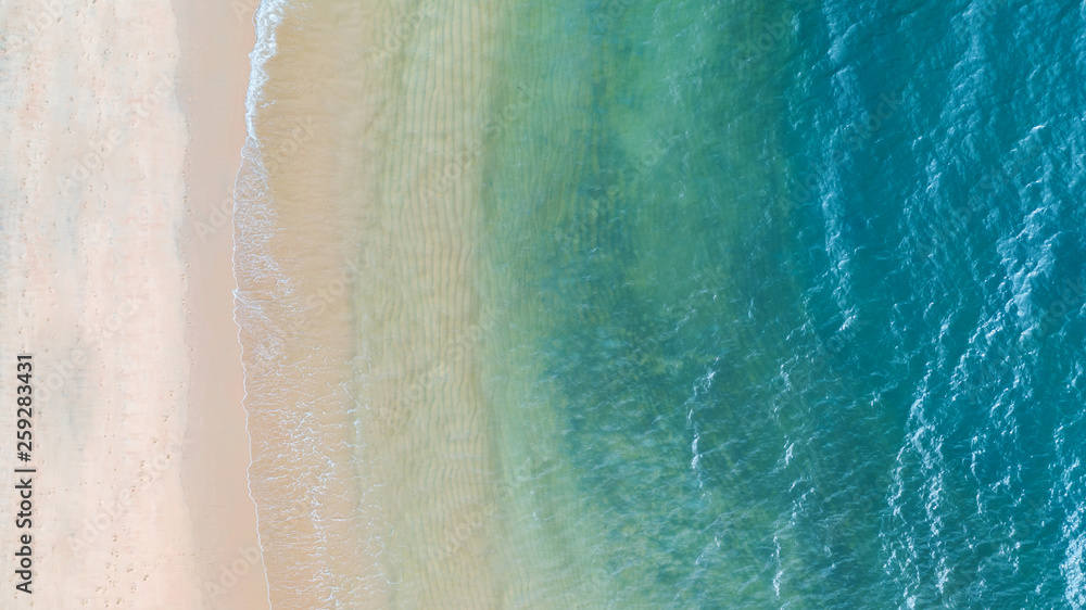 Aerial top view of Beach with shade emerald blue water and wave foam on tropical sea